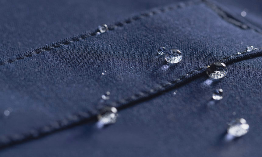 Gotas de agua sobre una tela azul marino resistente al agua